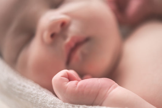 Sleeping newborn baby on soft white textile